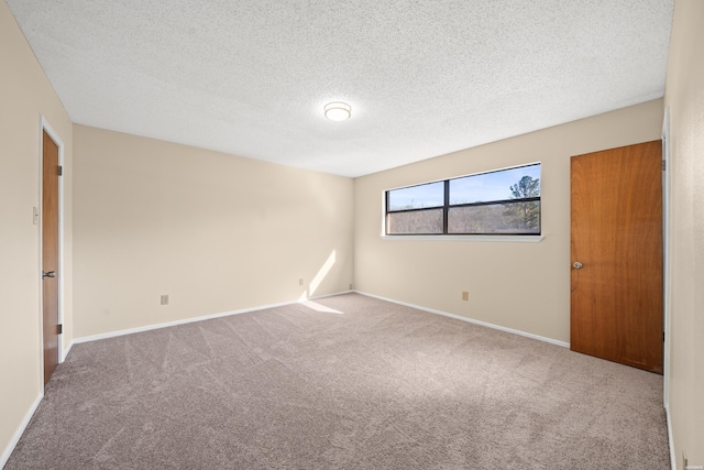 unfurnished bedroom with carpet floors, a textured ceiling, and baseboards