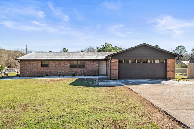 ranch-style home featuring concrete driveway, brick siding, an attached garage, and a front yard