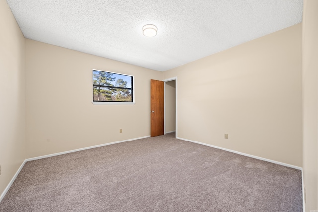 unfurnished room with baseboards, a textured ceiling, and light colored carpet