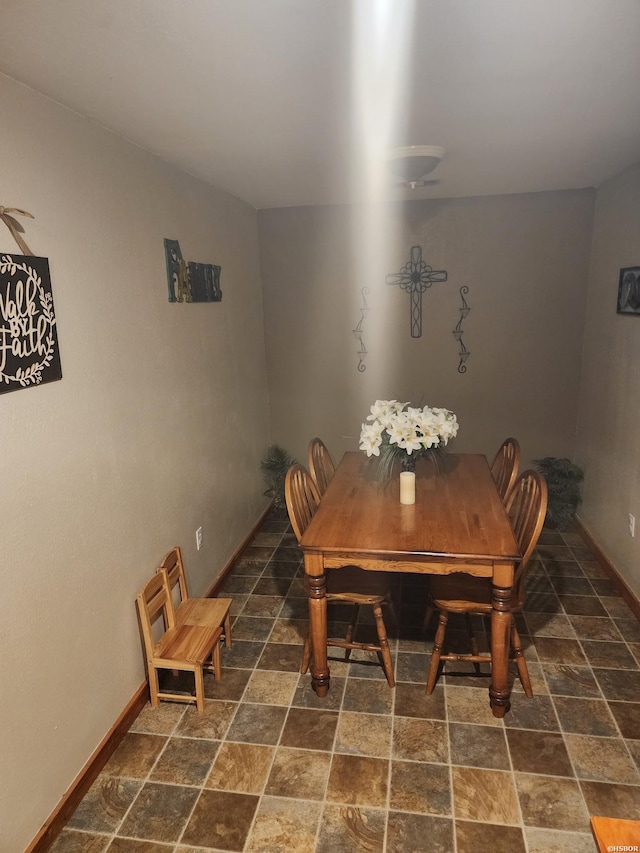 dining area with stone finish floor and baseboards
