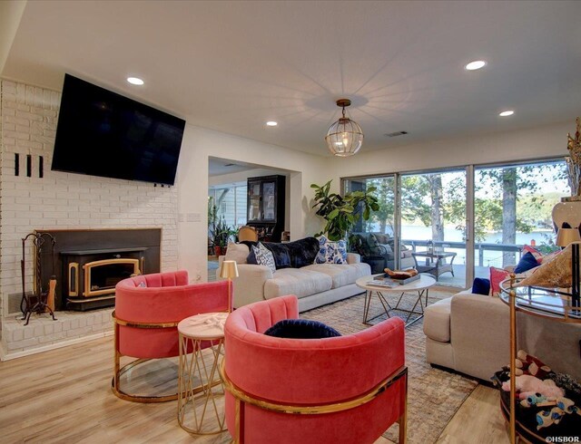 living area with light wood finished floors, a fireplace, visible vents, and recessed lighting