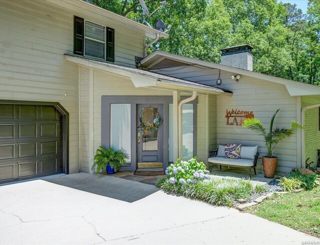 370 Restful Ridge Rd, Hot Springs, AR 71913 - property entrance with a chimney, concrete driveway, and an attached garage