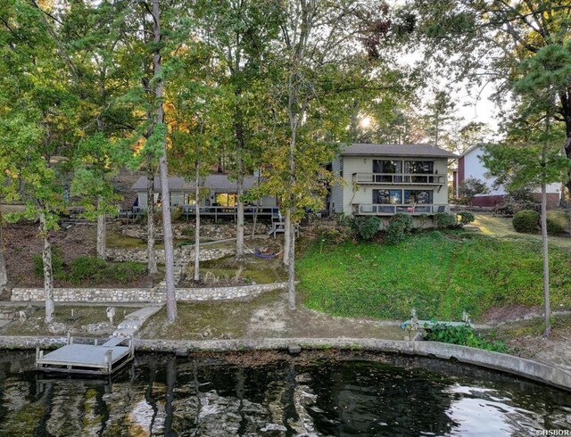 back of property featuring a water view and a balcony