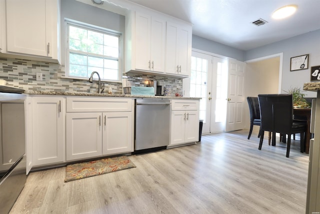 kitchen with stainless steel dishwasher, light wood-type flooring, white cabinetry, and a sink