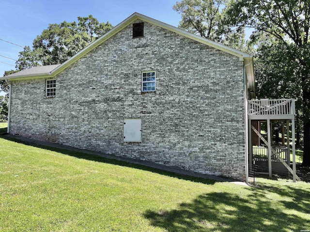 view of home's exterior featuring a yard, brick siding, and a deck