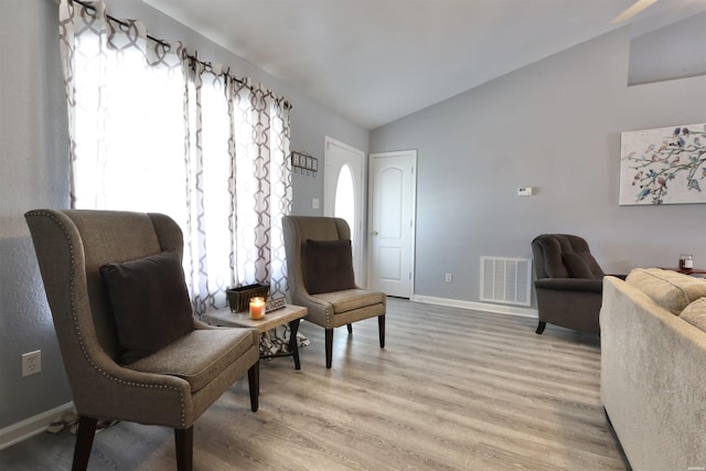 sitting room with vaulted ceiling, baseboards, visible vents, and light wood finished floors