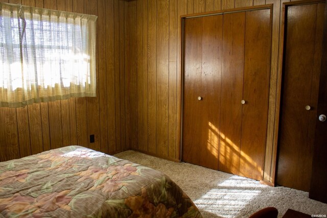 carpeted bedroom with wooden walls