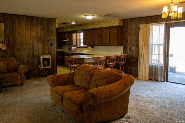 living area with a textured ceiling, wood walls, light carpet, and heating unit