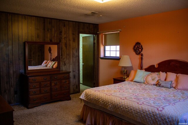 bedroom featuring wood walls, a textured ceiling, and light colored carpet