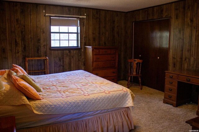 bedroom with carpet floors and wood walls