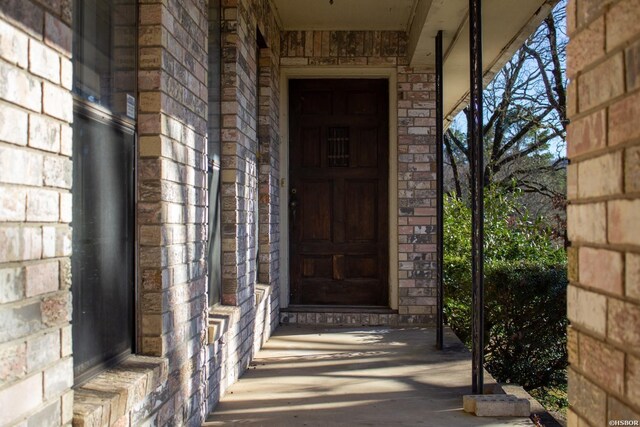 view of exterior entry with brick siding