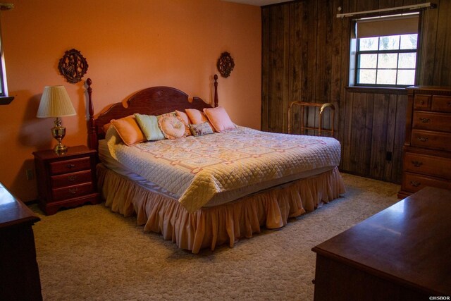 bedroom featuring carpet and wooden walls