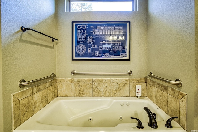 bathroom featuring a textured wall and a whirlpool tub