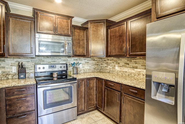 kitchen featuring light tile patterned floors, appliances with stainless steel finishes, light stone countertops, and tasteful backsplash