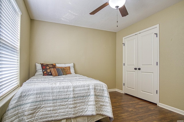 bedroom with a closet, wood finished floors, a ceiling fan, and baseboards