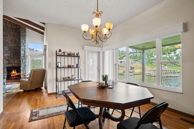 105 Long Island Bay Unit A1, Hot Springs, AR 71913 - dining room featuring a chandelier, a fireplace, plenty of natural light, light wood-type flooring, and vaulted ceiling