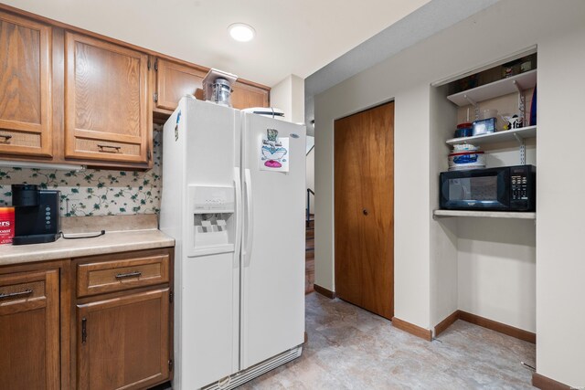 105 Long Island Bay Unit A1, Hot Springs, AR 71913 - kitchen featuring white fridge with ice dispenser, black microwave, light countertops, brown cabinetry, and tasteful backsplash