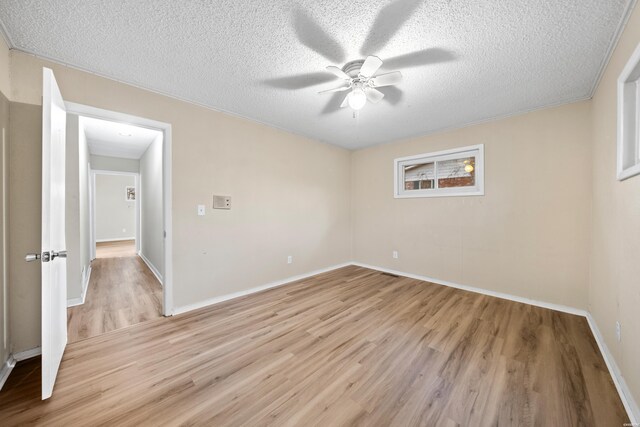 empty room featuring light wood-style flooring, ceiling fan, and a textured ceiling