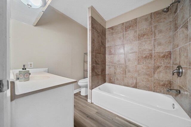 bathroom with vanity, shower / bath combination, wood finished floors, and toilet