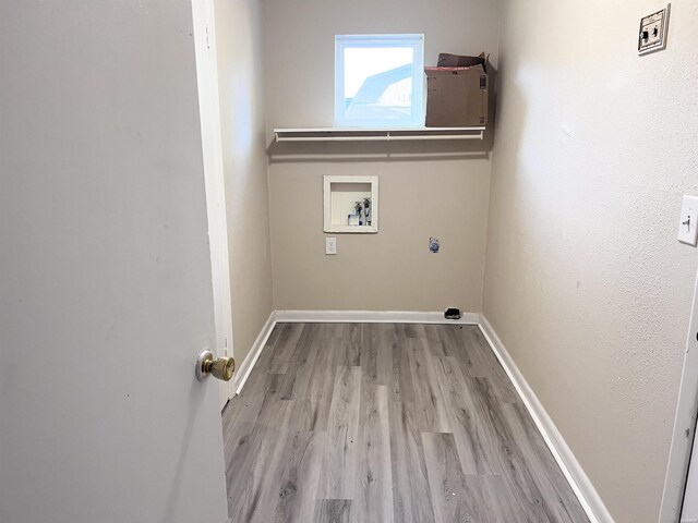 laundry area with laundry area, light wood finished floors, hookup for a washing machine, and baseboards