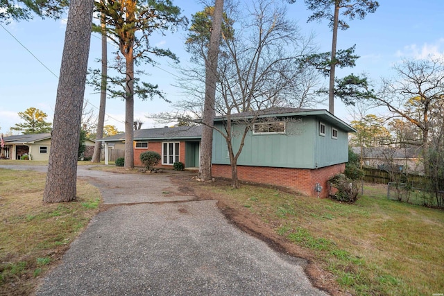 view of front of property featuring aphalt driveway and a front lawn