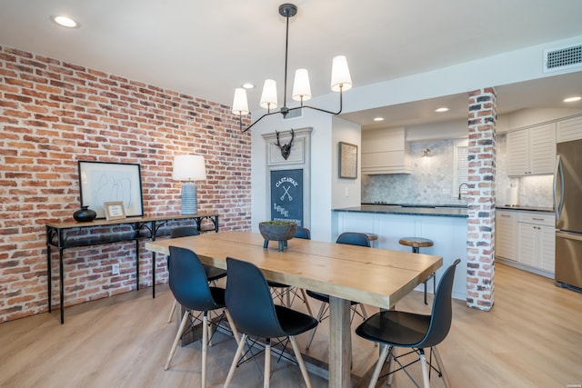 dining space featuring light wood-style floors, brick wall, visible vents, and recessed lighting