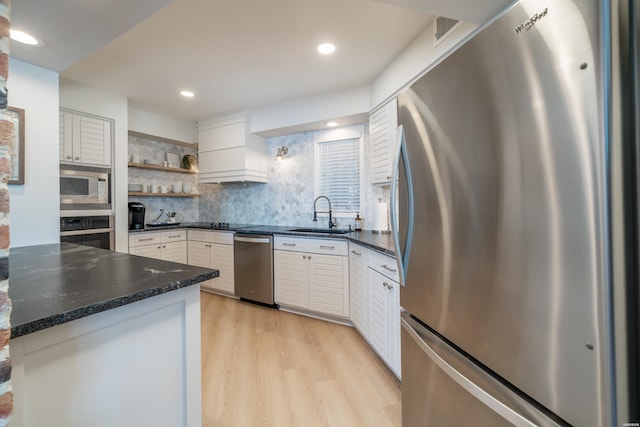 kitchen with a sink, stainless steel appliances, open shelves, and white cabinetry