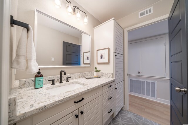 bathroom with visible vents, wood finished floors, and vanity