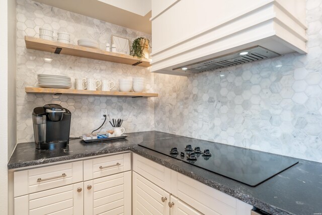 kitchen featuring black electric stovetop, premium range hood, decorative backsplash, dark stone counters, and open shelves