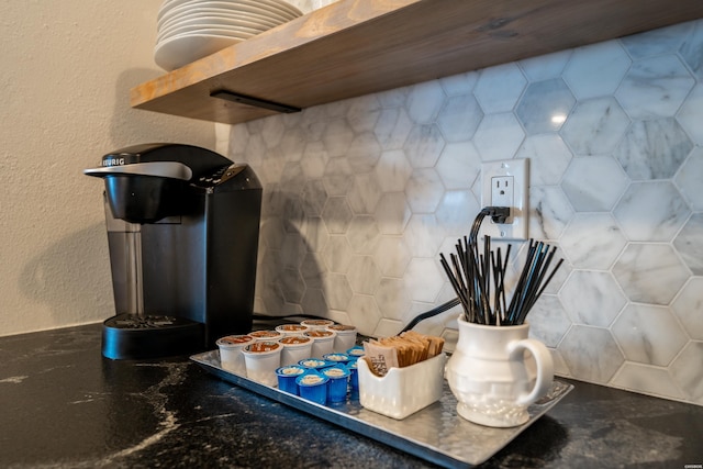 room details featuring dark countertops, open shelves, and a textured wall