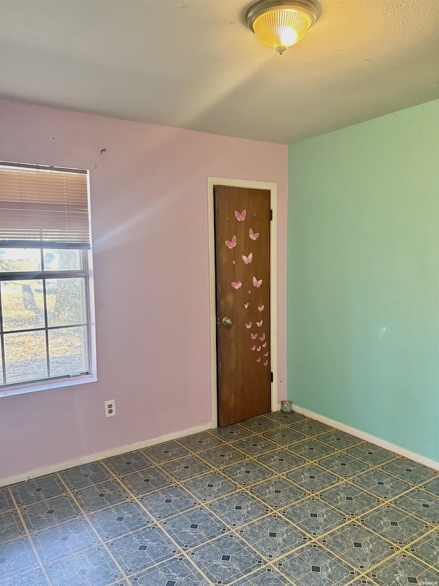 spare room with dark floors and baseboards