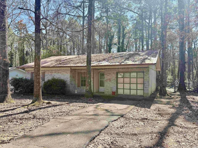 single story home featuring a garage, concrete driveway, and brick siding