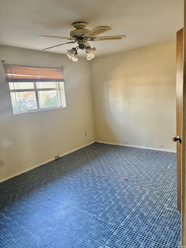 carpeted spare room with a ceiling fan