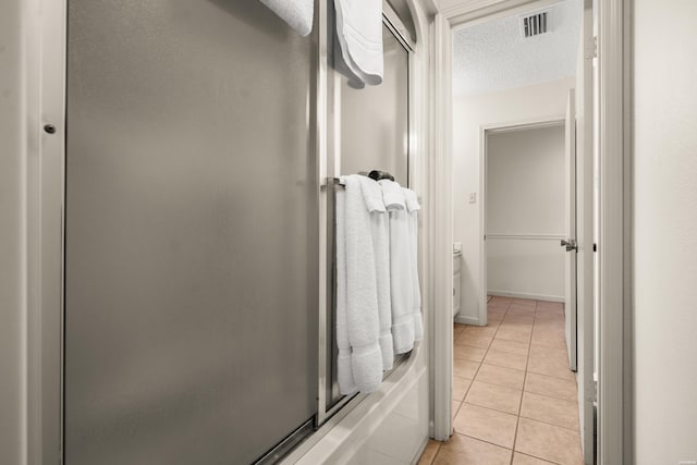 full bath featuring tile patterned flooring, visible vents, and a textured ceiling