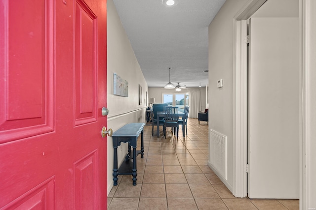 corridor featuring light tile patterned floors and visible vents