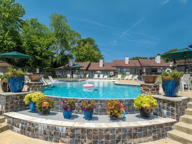 community pool with fence and a patio