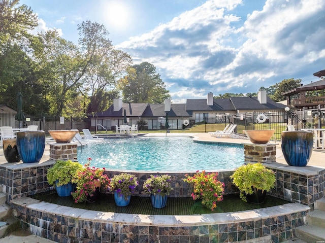 pool with a patio and fence