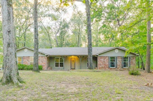 ranch-style house with a front yard and brick siding