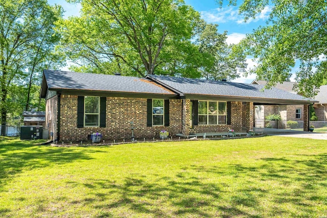 single story home featuring a carport, brick siding, a front lawn, and roof with shingles