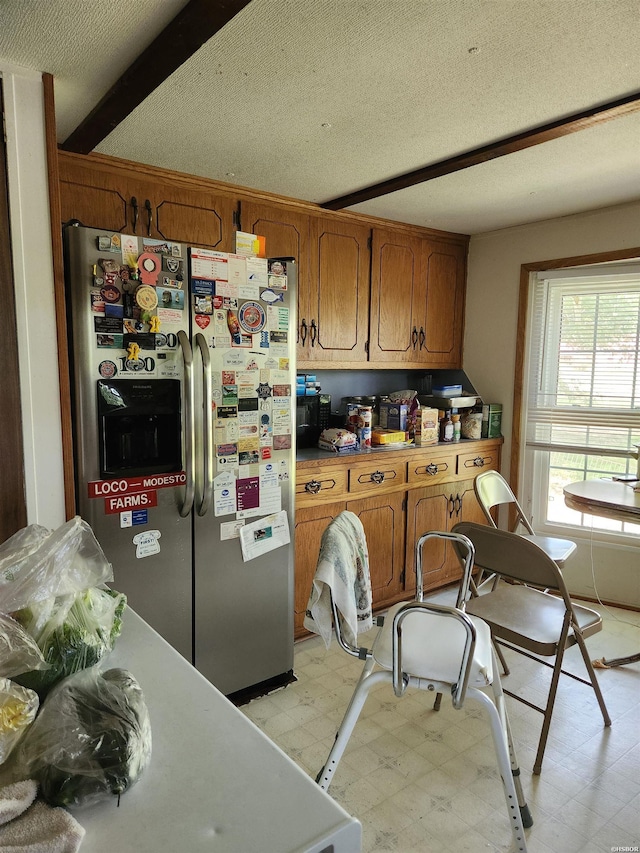 256 Shawnee Loop, Amity, AR 71921 - kitchen with stainless steel fridge with ice dispenser, light floors, brown cabinetry, a textured ceiling, and light countertops