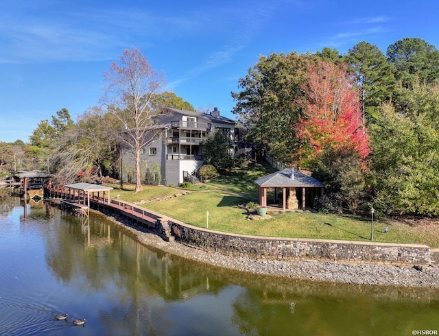 view of dock featuring a water view, a lawn, and a gazebo