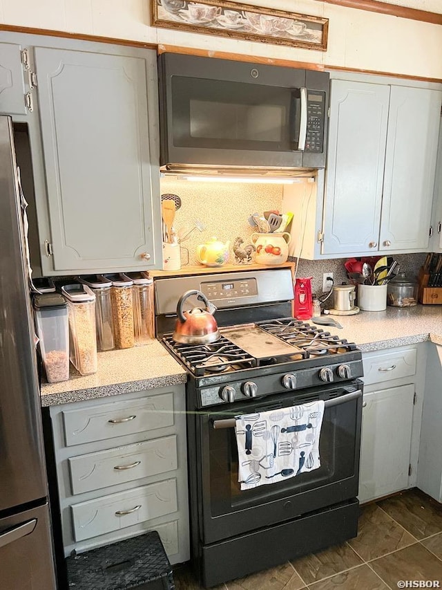 kitchen featuring appliances with stainless steel finishes, light countertops, white cabinetry, and tasteful backsplash