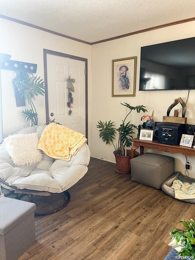 living room featuring crown molding, a textured ceiling, and wood finished floors