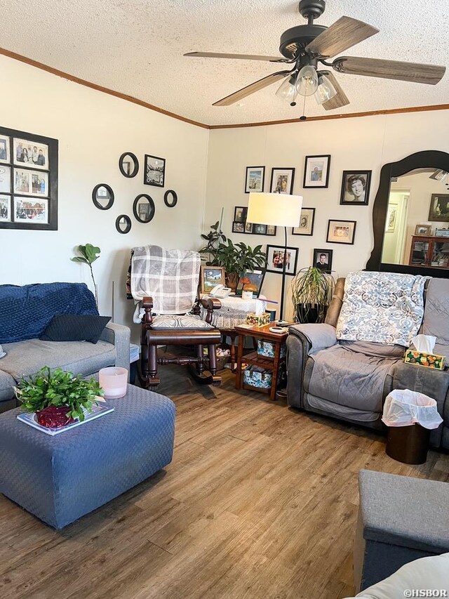 living room with arched walkways, a textured ceiling, wood finished floors, and crown molding