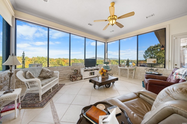 sunroom featuring a ceiling fan, visible vents, and plenty of natural light