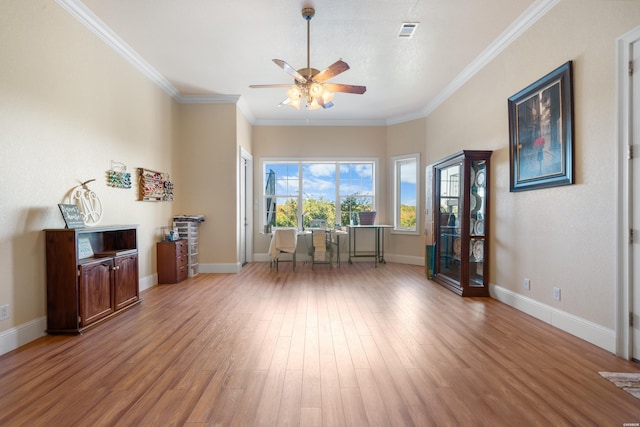 interior space featuring ornamental molding, wood finished floors, visible vents, and baseboards