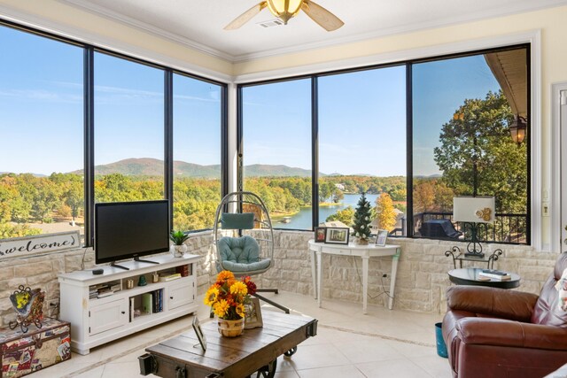 living room featuring a wealth of natural light, ceiling fan, visible vents, and crown molding