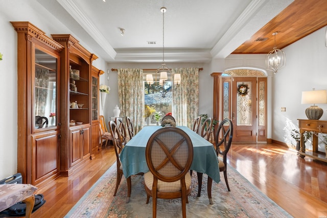 dining area with a raised ceiling, visible vents, a notable chandelier, and light wood-style flooring