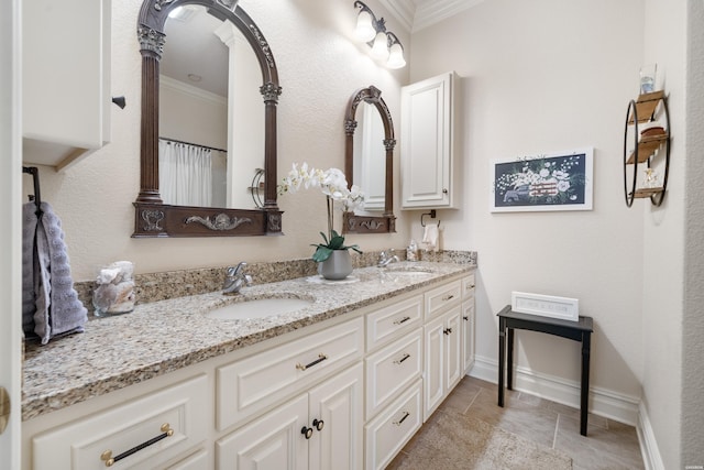 bathroom with baseboards, double vanity, a sink, and crown molding