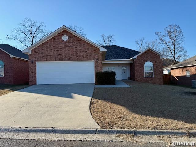 ranch-style house with brick siding, driveway, and an attached garage